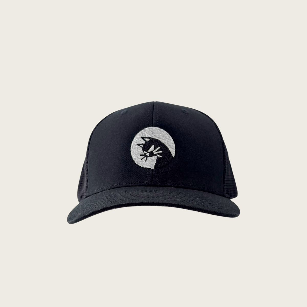 Bad Cat mesh-back trucker cap in black, front view, embroidered cat mark