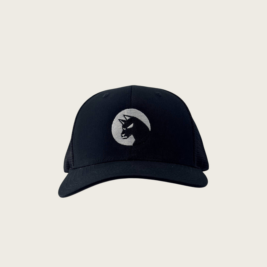 Bad Dog mesh-back trucker cap in black, front view, embroidered dog mark